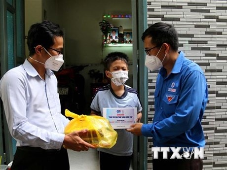 Đoàn thanh niên Tổng Công ty Điện lực Thành phố Hồ Chí Minh và Quận 4 tặng máy tính bảng trong chương trình “Tuổi trẻ EVN thắp sáng niềm tin” cho trẻ mồ côi do dịch COVID-19 ở Quận 4. (Ảnh: Thanh Vũ/TTXVN)