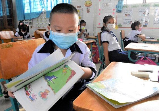 Bé Nguyễn Thiện Nhân (lớp 1/2 Trường Tiểu học Thạnh An) chuẩn bị sách tập