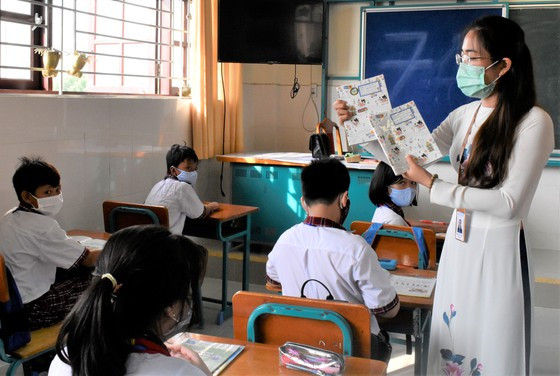 Cô Đinh Thu Hiền, giáo viên lớp 6/2 hướng dẫn cho học sinh chuẩn bị sách tập trước khi bước vào môn học