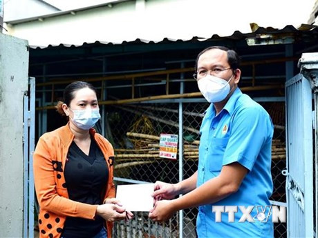Liên đoàn Lao động Bình Tân trao quà hỗ trợ cho công nhân, người lao động có hoàn cảnh khó khăn ở khu trọ bị ảnh hưởng bởi dịch COVID-19. (Ảnh: Thanh Vũ/TTXVN)