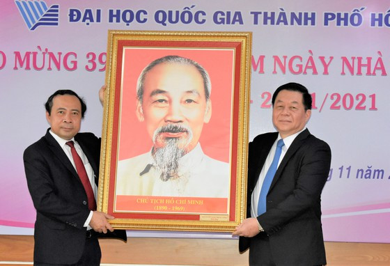 Đồng chí Nguyễn Trọng Nghĩa, Trưởng Ban Tuyên giáo Trung ương (bên phải) trao tặng hình Bác Hồ cho PGS-TS Vũ Hải Quân, Giám đốc ĐHQG TPHCM