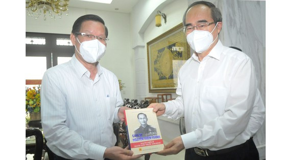 Chủ tịch UBND TPHCM Phan Văn Mãi nhận sách về GS Nguyễn Thiện Thành do GS-TS Nguyễn Thiện Nhân tặng. Ảnh: CAO THĂNG