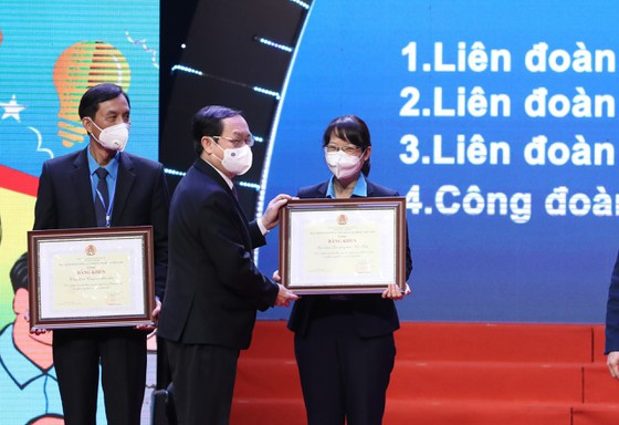 Bộ trưởng Bộ KH-CN Huỳnh Thành Đạt trao bằng khen cho Chủ tịch LĐLĐ TPHCM Trần Thị Diệu Thúy. Ảnh: VIẾT CHUNG