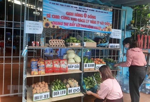 Người dân mang rau, hàng hóa đến để góp vào gian hàng 0 đồng hỗ trợ người ở điểm cách ly phường Tân Quý, quận Tân Phú. (Ảnh: TTXVN phát)