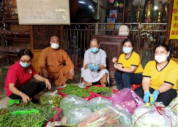 Thượng Tọa Thích Thiện Ngọc, trụ trì Chùa Phổ Minh, phường 15, quận Tân Bình cùng phật tử chuẩn bị cơm chay tặng các hộ dân khu vực phong tỏa và hộ lao động có hoàn cảnh khó khăn. (Ảnh: TTXVN phát)
