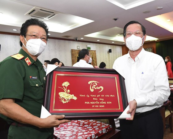 Chủ tịch UBND TPHCM Phan Văn Mãi tặng quà PGS Nguyễn Hồng Sơn. Ảnh: VIỆT DŨNG