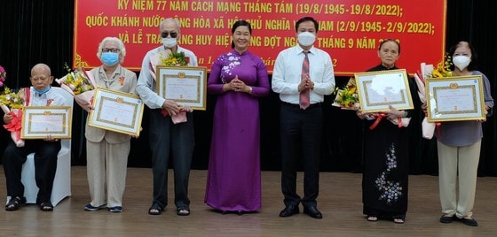 Phó Bí thư Thường trực Quận ủy quận 1 Hoàng Thị Tố Nga tặng Huy hiệu 60 năm tuổi Đảng cho các đảng viên. Ảnh: PHƯƠNG UYÊN