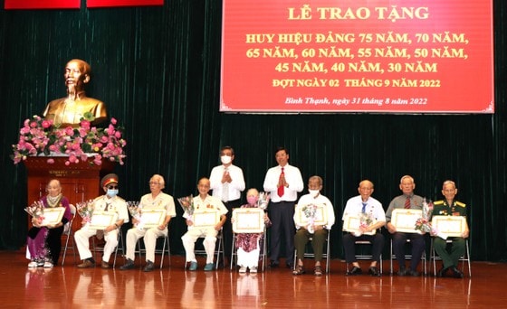 Đồng chí Nguyễn Phước Lộc chúc mừng các đảng viên nhận Huy hiệu 75 năm tuổi Đảng. Ảnh: THÁI PHƯƠNG