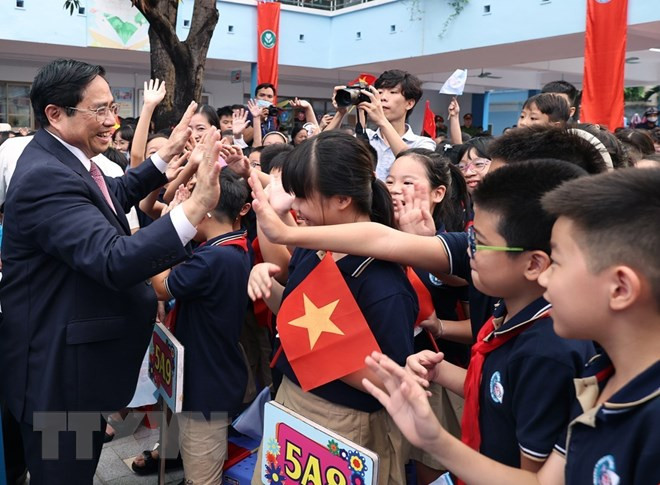 Thủ tướng Phạm Minh Chính với học sinh Trường Tiểu học Đoàn Thị Điểm. (Ảnh: Dương Giang/TTXVN)