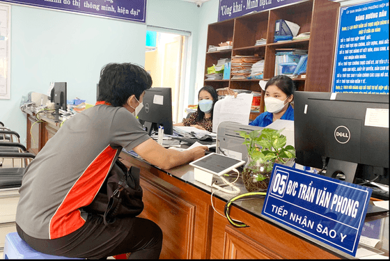 Cán bộ, công chức UBND phường Hiệp Bình Chánh (TP Thủ Đức) giải quyết thủ tục hành chính cho người dân. Ảnh: THU HƯỜNG