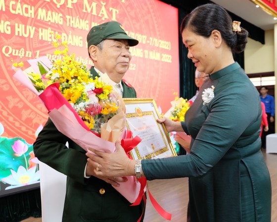 Phó Bí thư Thường trực Quận ủy quận 1 Hoàng Thị Tố Nga trao Huy hiệu 60 năm tuổi Đảng cho đảng viên. Ảnh: THU HƯỜNG