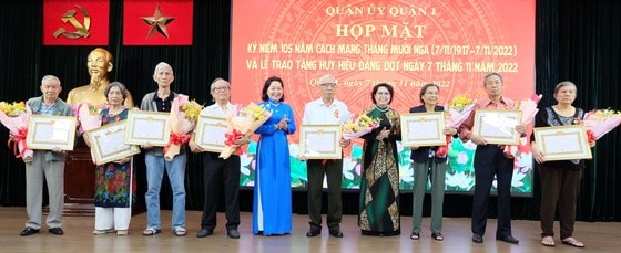 Các đảng viên thuộc Đảng bộ quận 1 nhận Huy hiệu 55 năm Đảng. Ảnh: THU HƯỜNG