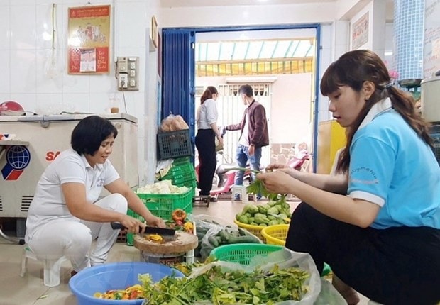 Các thành viên tại Bếp yêu thương cùng nhau sơ chế rau củ để chuẩn bị cho buổi nấu ăn tiếp theo. (Ảnh: Thu Hương/TTXVN)