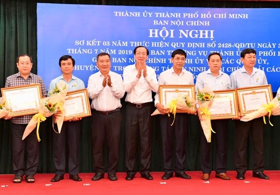 Trưởng Ban Nội chính Thành ủy TPHCM Lê Thanh Liêm và Phó Trưởng Ban Thường trực Nội chính Thành ủy TPHCM Trần Văn Thuận trao bằng khen cho các tập thể. Ảnh: VIỆT DŨNG