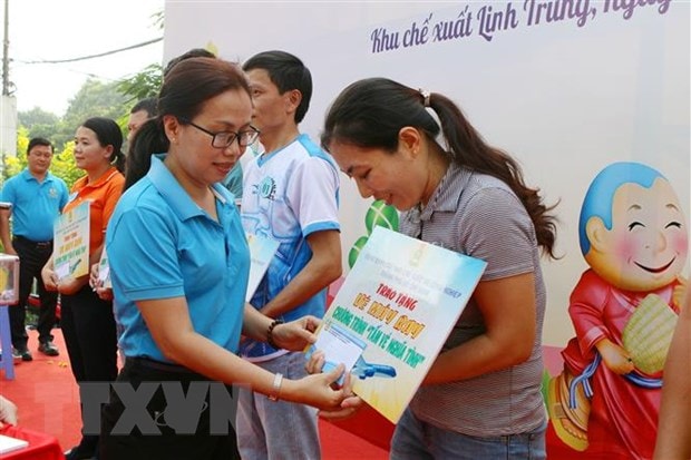 Đại diện Ban Quản lý Hepza Thành phố Hồ Chí Minh trao tấm vé nghĩa tình cho công nhân lao động Khu chế xuất Linh Trung. (Ảnh: Thanh Vũ/TTXVN)