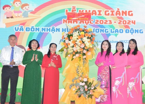 Chủ tịch HĐND TPHCM Nguyễn Thị Lệ tặng hoa chúc mừng Trường Tiểu học Minh Đạo, quận 5 khai giảng năm học mới. Ảnh: CAO THĂNG