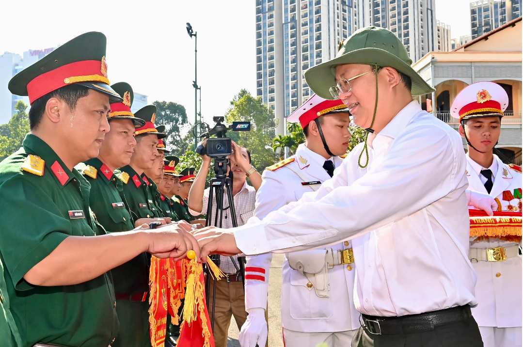 Phó Bí thư Thường trực Thành ủy TPHCM tặng cờ lưu niệm cho các đơn vị tham gia. Ảnh: VIỆT DŨNG