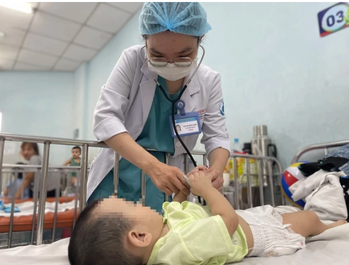 Bác sĩ Khoa Nhiễm - thần kinh Bệnh viện Nhi đồng 1 đang khám cho bệnh nhi mắc tay chân miệng. Ảnh chụp ngày 11.6