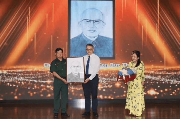 Kiến trúc sư Lê Văn Minh (trái) trao tặng bức chân dung Bác Tôn cho Bảo tàng Tôn Đức Thắng (TP.HCM) trong buổi họp mặt