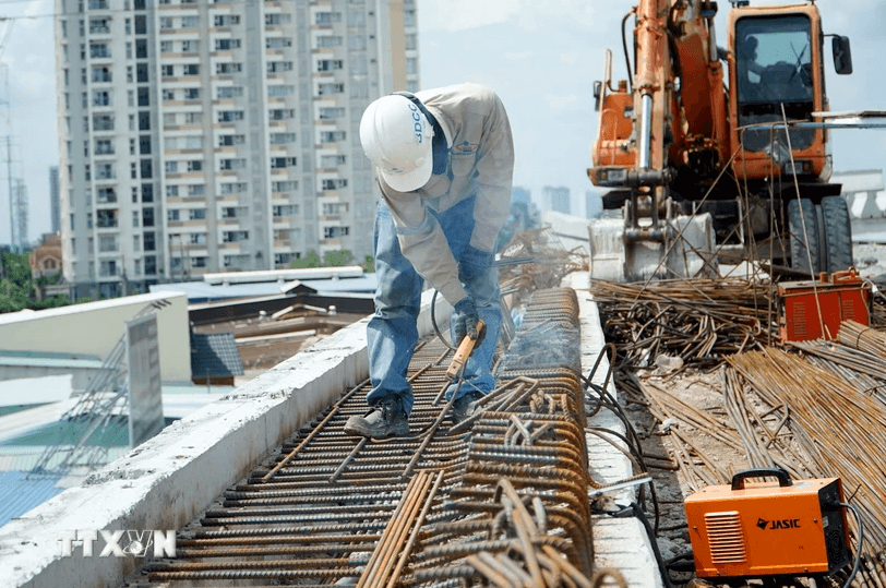 ông nhân thi công trên công trường dự án xây dựng cầu Nam Lý. (Ảnh: Tiến Lực/TTXVN)