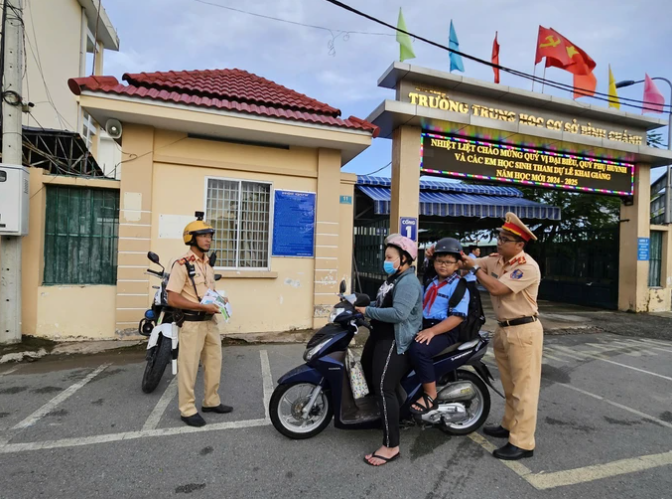 CSGT TPHCM tuyên truyền phát tờ rơi, tặng mũ bảo hiểm mới cho học sinh