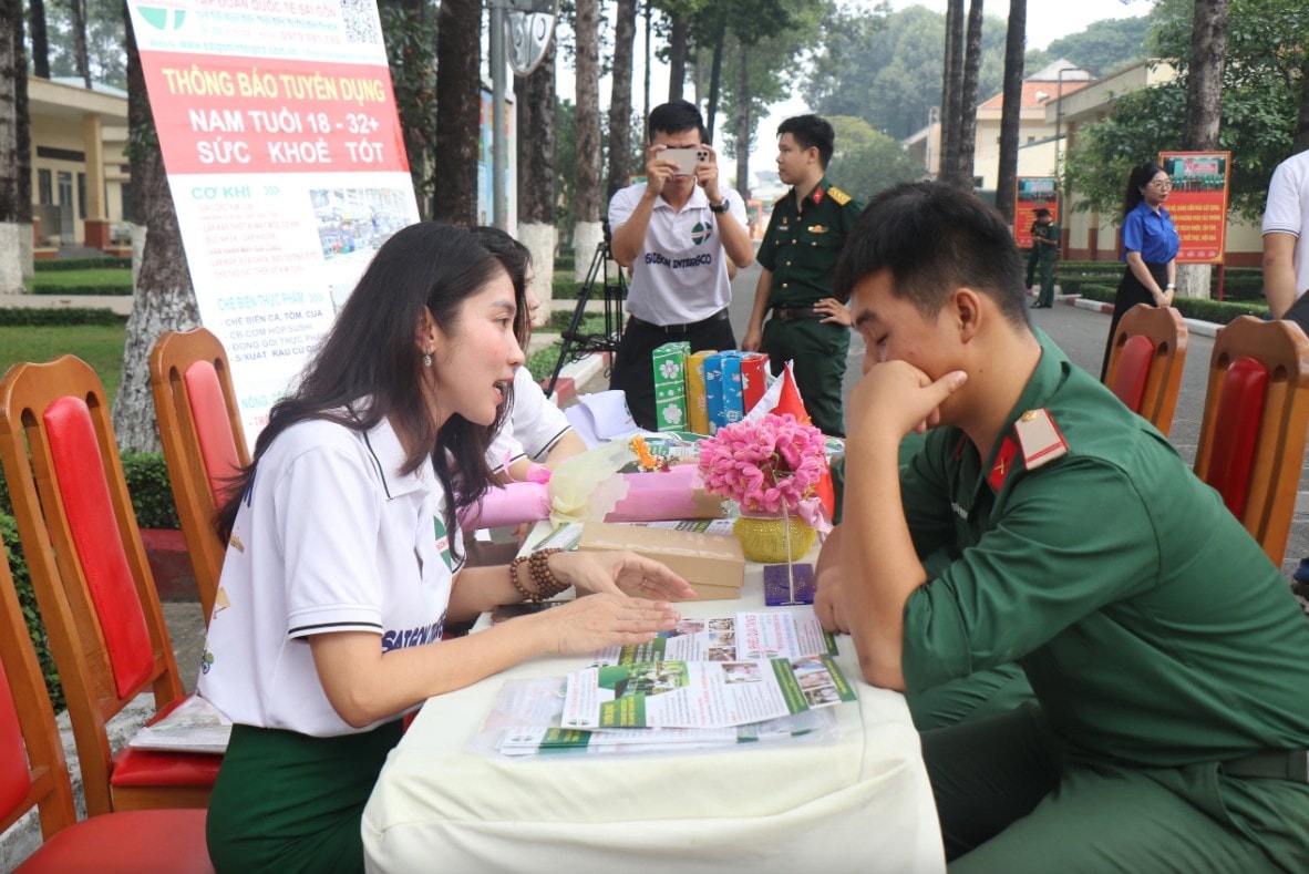 Chị Phùng Dương Trang (trái) giới thiệu các chương trình của công ty cho quân nhân. ẢNH: THÚY LIỄU